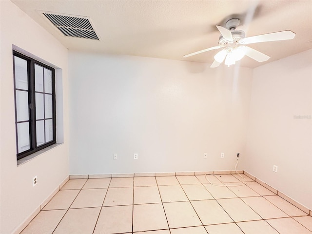 tiled empty room featuring ceiling fan