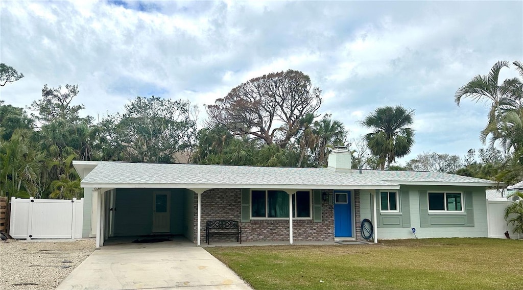 ranch-style home featuring a carport and a front lawn