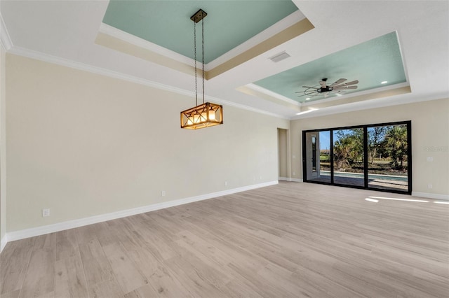 spare room featuring ornamental molding, a raised ceiling, and light hardwood / wood-style floors