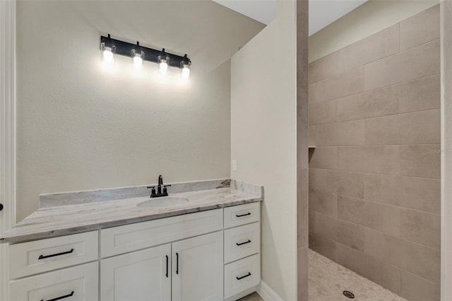 bathroom with vanity and tiled shower