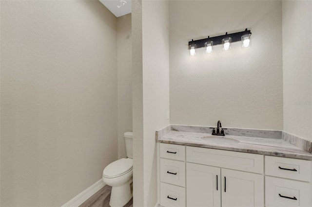 bathroom with vanity, hardwood / wood-style floors, and toilet