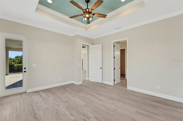 spare room featuring ornamental molding, light hardwood / wood-style floors, and a raised ceiling