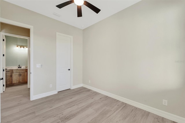 unfurnished bedroom featuring ceiling fan, sink, and light hardwood / wood-style flooring