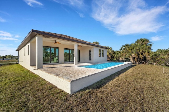 back of house with ceiling fan, a patio area, and a lawn