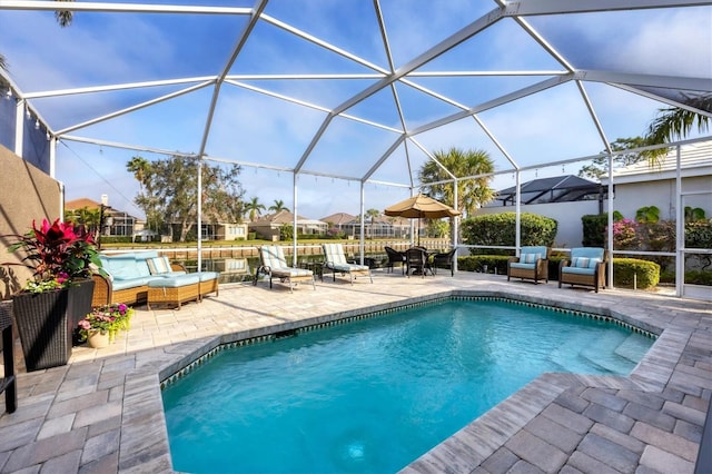 view of pool featuring an outdoor living space, a patio, and a lanai