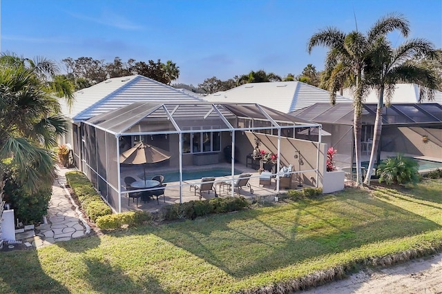 rear view of property with a patio, a lanai, and a lawn