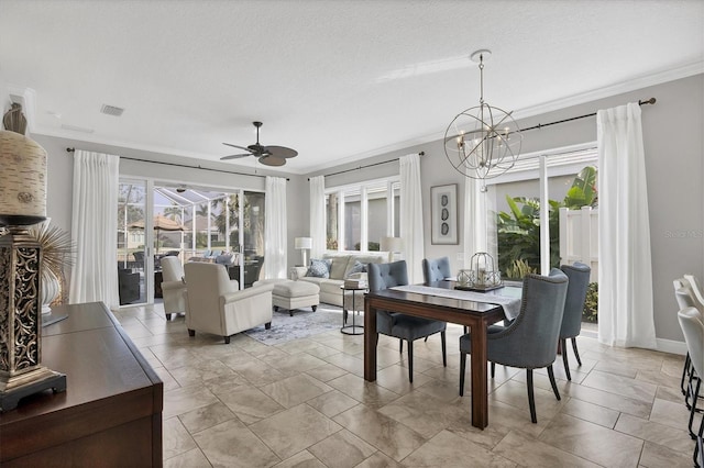 dining room featuring crown molding, ceiling fan with notable chandelier, and a textured ceiling