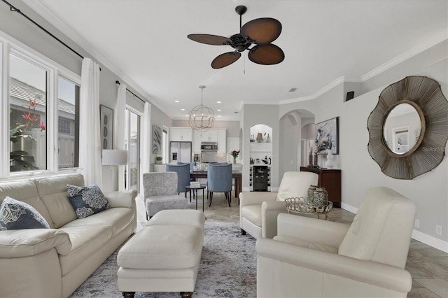 living room with ceiling fan with notable chandelier and ornamental molding