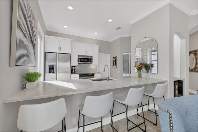 kitchen featuring stainless steel appliances, sink, white cabinets, and kitchen peninsula