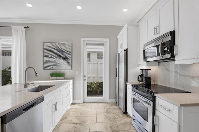 kitchen featuring sink, white cabinetry, crown molding, appliances with stainless steel finishes, and backsplash