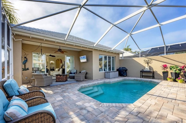 view of pool featuring ceiling fan, an outdoor hangout area, a patio area, and glass enclosure