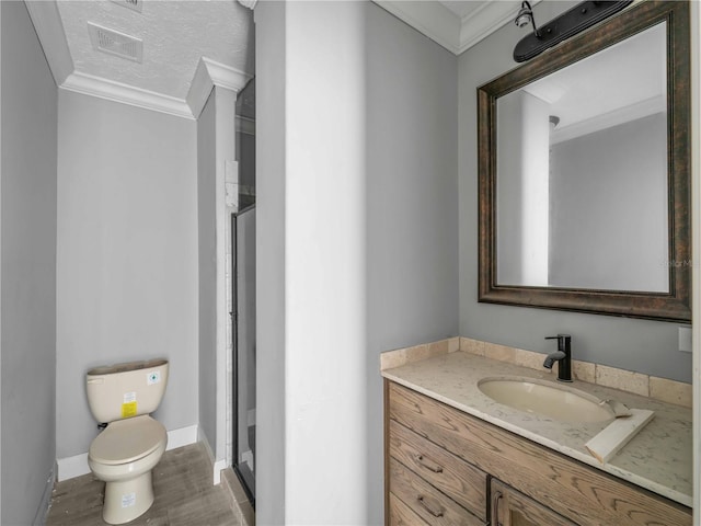 bathroom featuring an enclosed shower, crown molding, vanity, and toilet