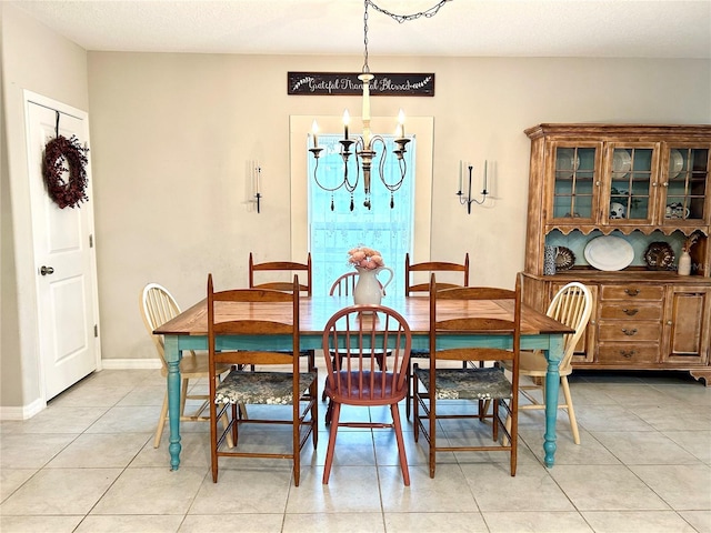 dining space featuring light tile patterned flooring and a notable chandelier