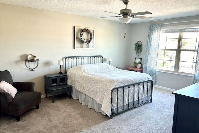 carpeted bedroom with ceiling fan and a textured ceiling