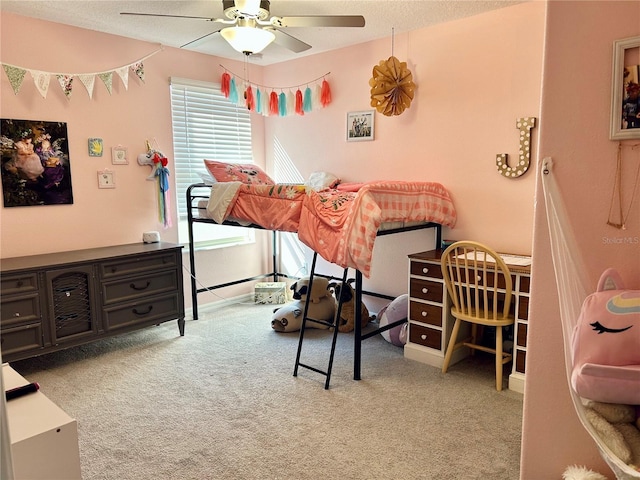 bedroom featuring a textured ceiling, light colored carpet, and ceiling fan