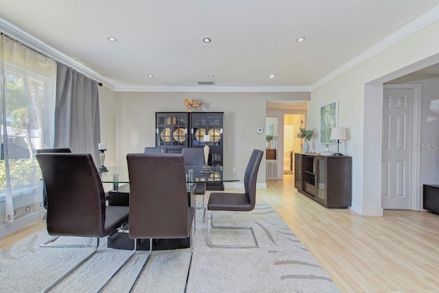 dining room featuring baseboards, recessed lighting, light wood-type flooring, and crown molding