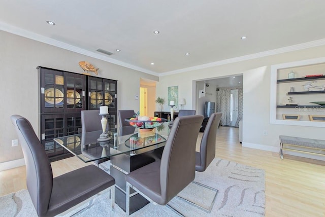 dining space featuring built in features, visible vents, ornamental molding, wood finished floors, and baseboards