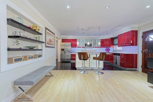 kitchen featuring appliances with stainless steel finishes, red cabinetry, ornamental molding, and wood finished floors