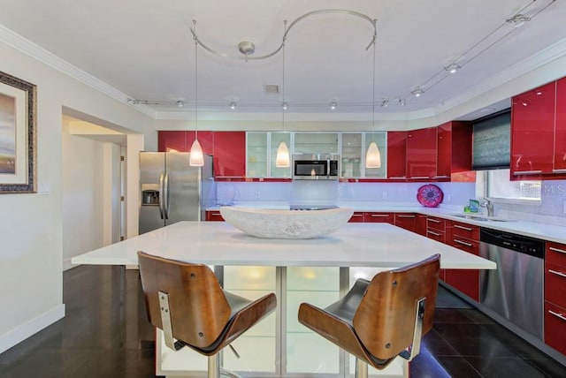 kitchen with a sink, appliances with stainless steel finishes, red cabinets, a center island, and tasteful backsplash