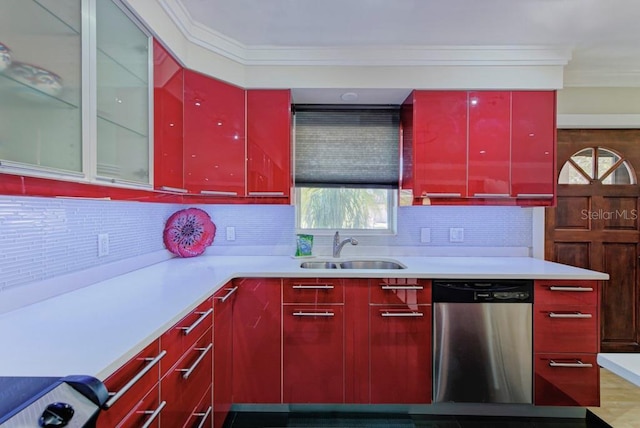 kitchen featuring backsplash, ornamental molding, red cabinetry, a sink, and dishwasher