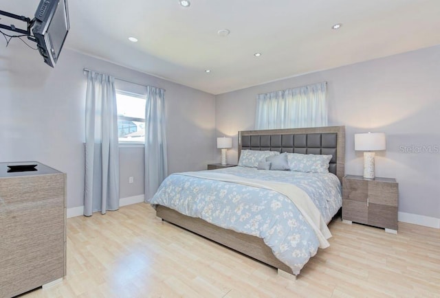 bedroom with baseboards, wood finished floors, and recessed lighting