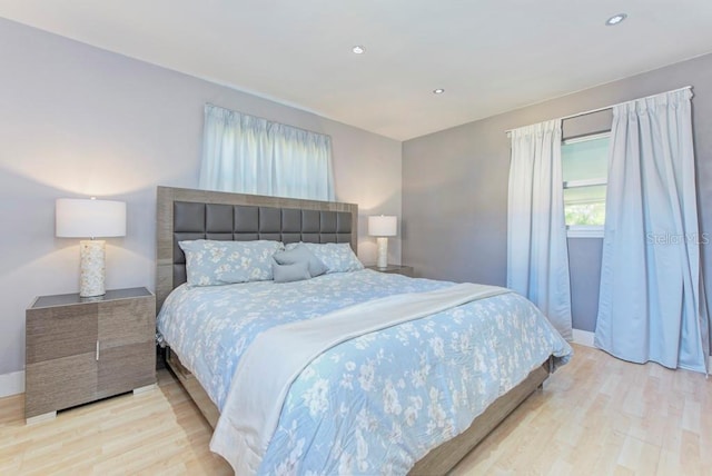 bedroom featuring baseboards, wood finished floors, and recessed lighting