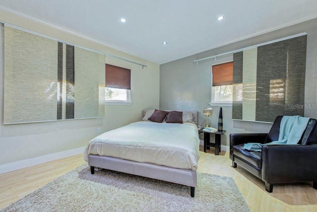 bedroom with baseboards, wood finished floors, and recessed lighting