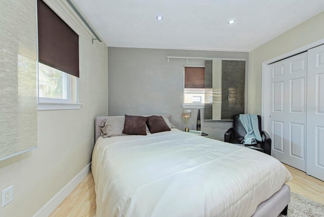 bedroom with light wood finished floors, baseboards, a closet, and recessed lighting