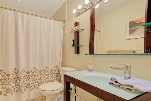 bathroom featuring a shower with shower curtain, vanity, and toilet