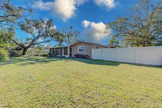 view of yard with fence and a sunroom