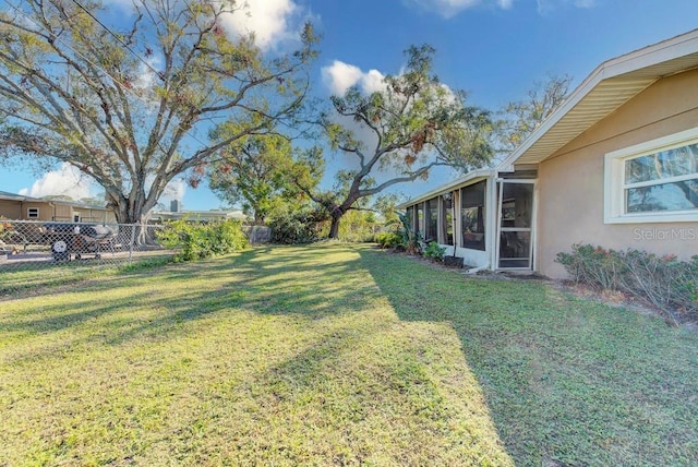 view of yard featuring a fenced backyard and a sunroom