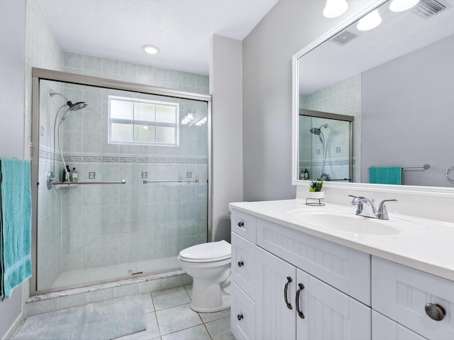 bathroom with vanity, tile patterned flooring, a shower with door, and toilet