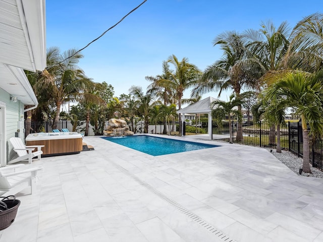 view of swimming pool featuring a hot tub, a gazebo, a water view, and a patio area