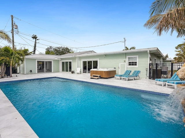 view of pool with a hot tub and a patio