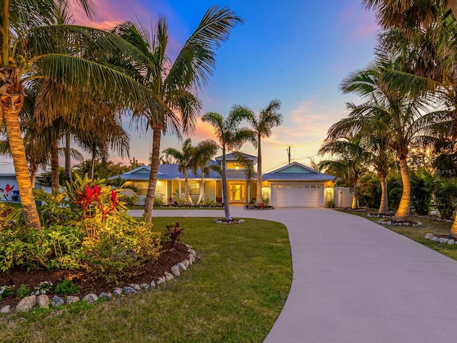 view of front of property with a garage and a lawn