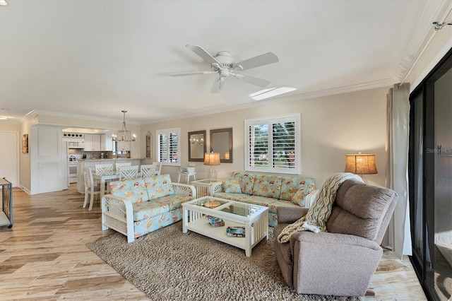 living room featuring crown molding, ceiling fan with notable chandelier, and light hardwood / wood-style floors