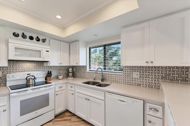 kitchen featuring white cabinetry, sink, backsplash, and white appliances