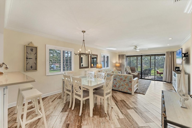 dining space featuring crown molding, ceiling fan with notable chandelier, and light hardwood / wood-style floors