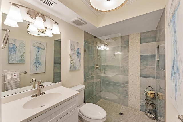 bathroom with vanity, tiled shower, and toilet