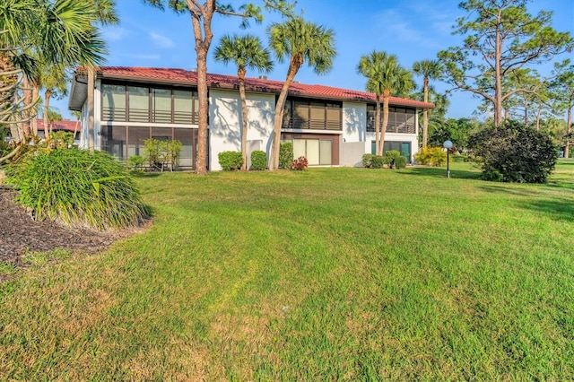 back of house with a sunroom and a yard