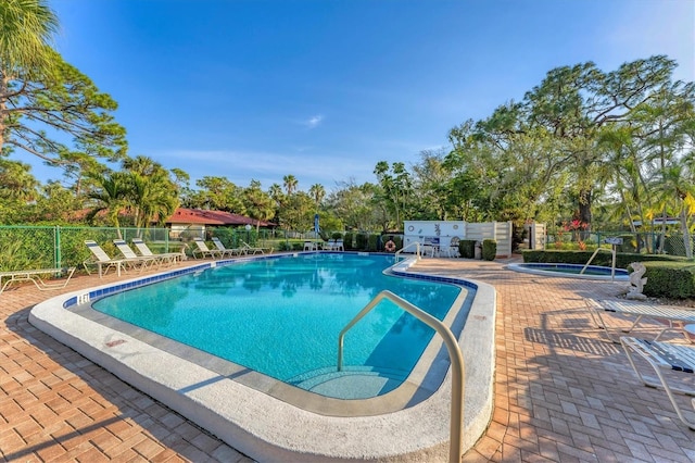 view of pool with a hot tub and a patio