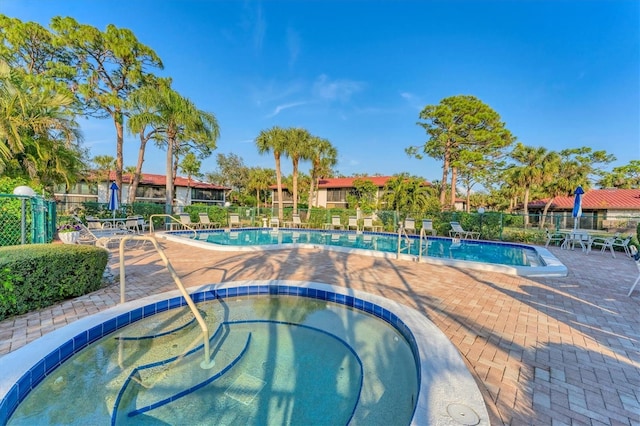 view of pool featuring a hot tub and a patio