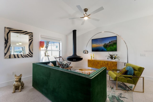 living room featuring ceiling fan, lofted ceiling, and a wood stove