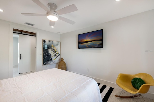 bedroom with a barn door and ceiling fan