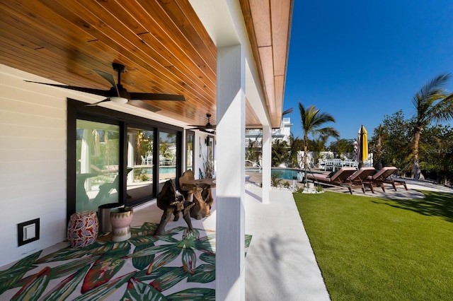 view of patio featuring a community pool and ceiling fan