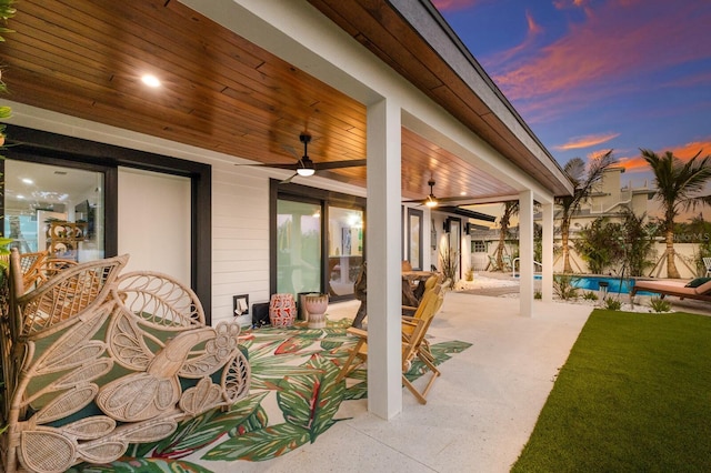 patio terrace at dusk featuring ceiling fan