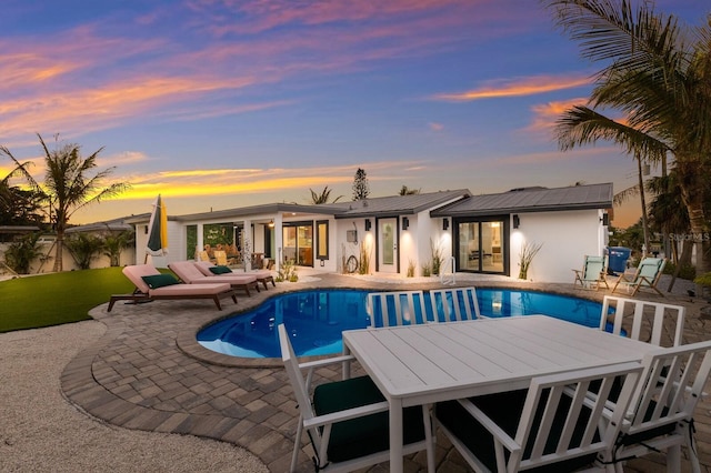 pool at dusk with a patio