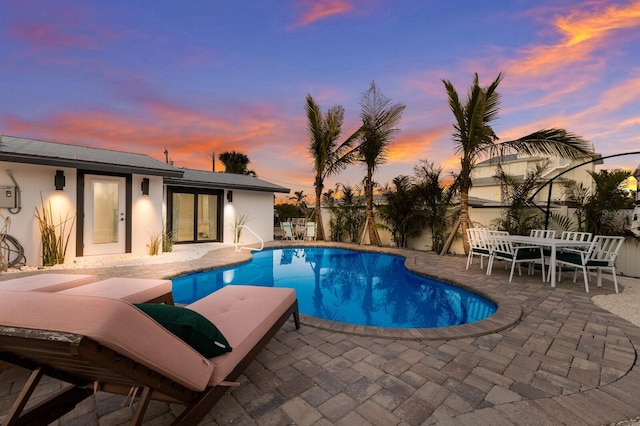 pool at dusk with a patio