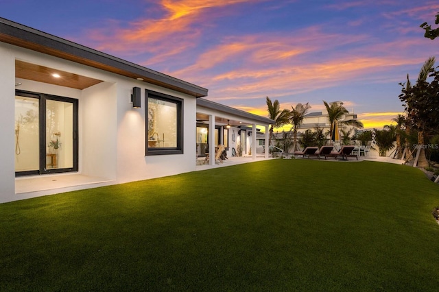 yard at dusk featuring a patio area