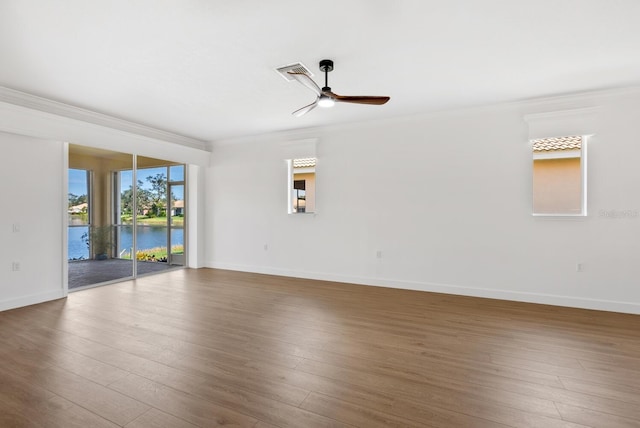 unfurnished room featuring wood-type flooring, ornamental molding, ceiling fan, and a water view